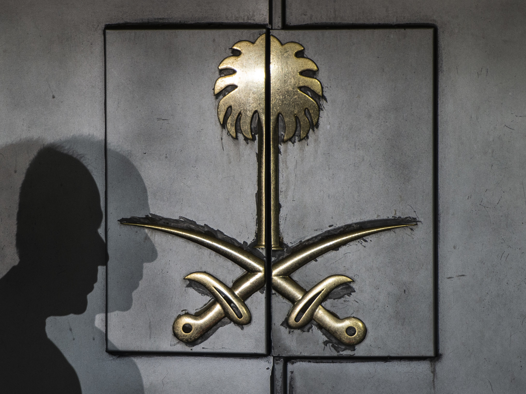 caption: The shadow of a security guard rests atop the front door of the Saudi consulate Friday in Istanbul. Journalist Jamal Khashoggi vanished after visiting the building earlier this month, and simmering international suspicion puts the Saudi government behind his murder.