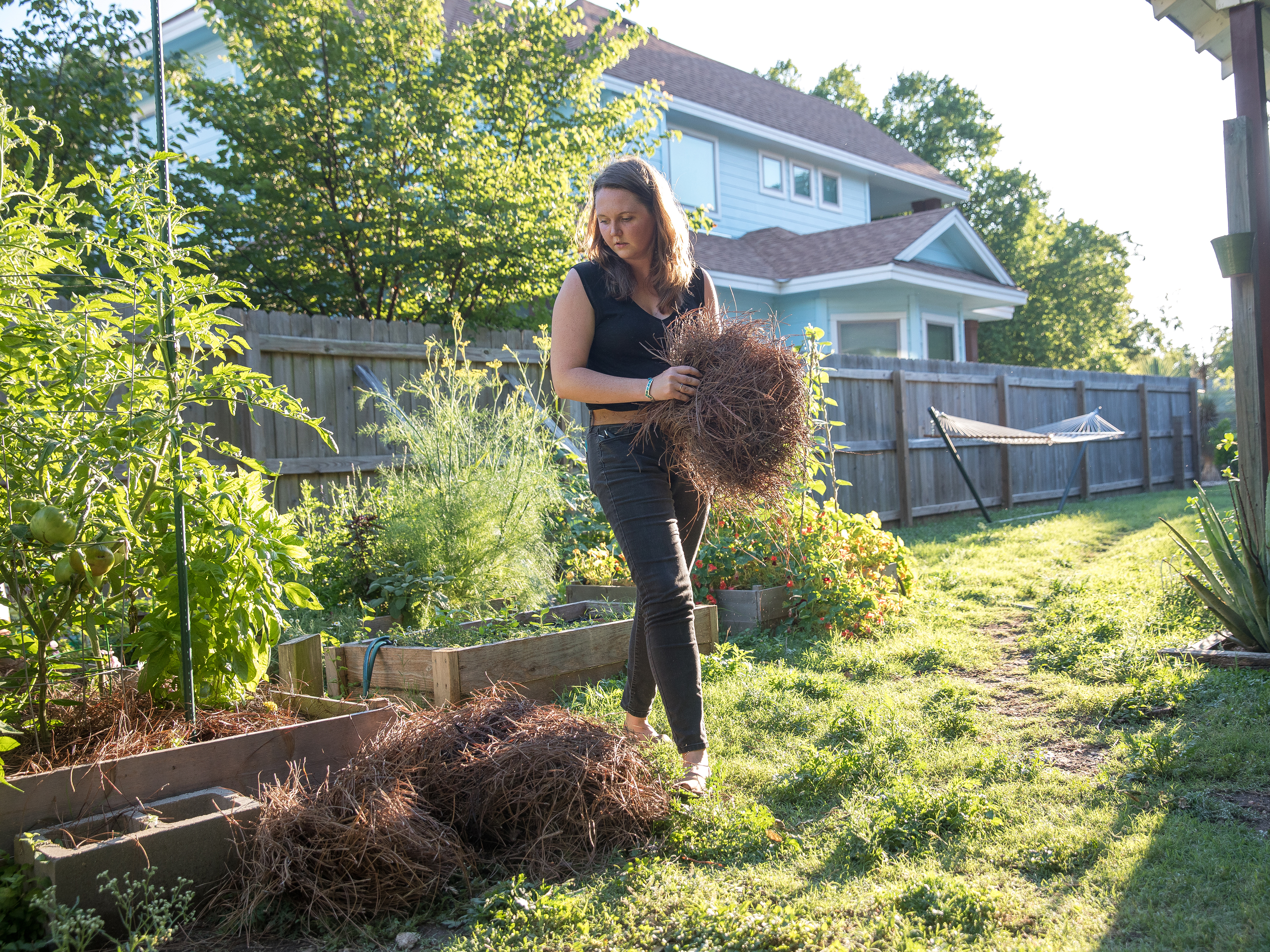 caption: Since her spinal surgery, Liv Cannon has been able to work in the garden and play with her energetic dogs without having to worry about pain.
