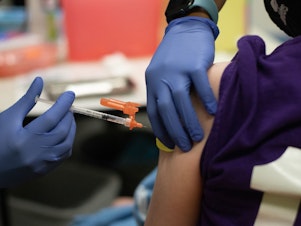 caption: A health care worker administers a dose of the Pfizer-BioNTech COVID-19 vaccine to a child at a pediatrician's office in Bingham Farms, Michigan. Federal agencies are considering whether to start giving the vaccine to children ages 5 to 11 in the near future.