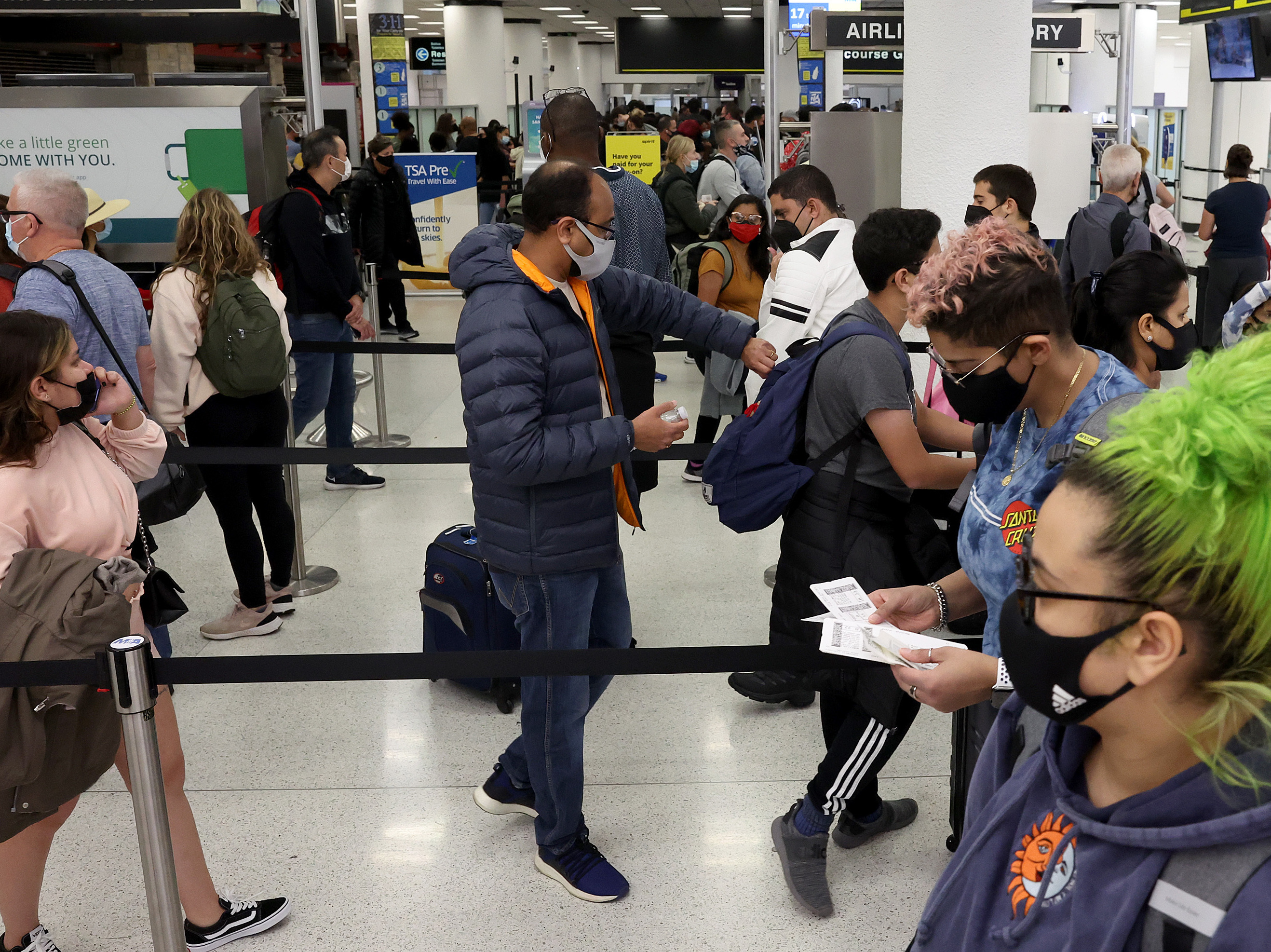 caption: Travelers make their way through Miami International Airport on Tuesday in Miami.