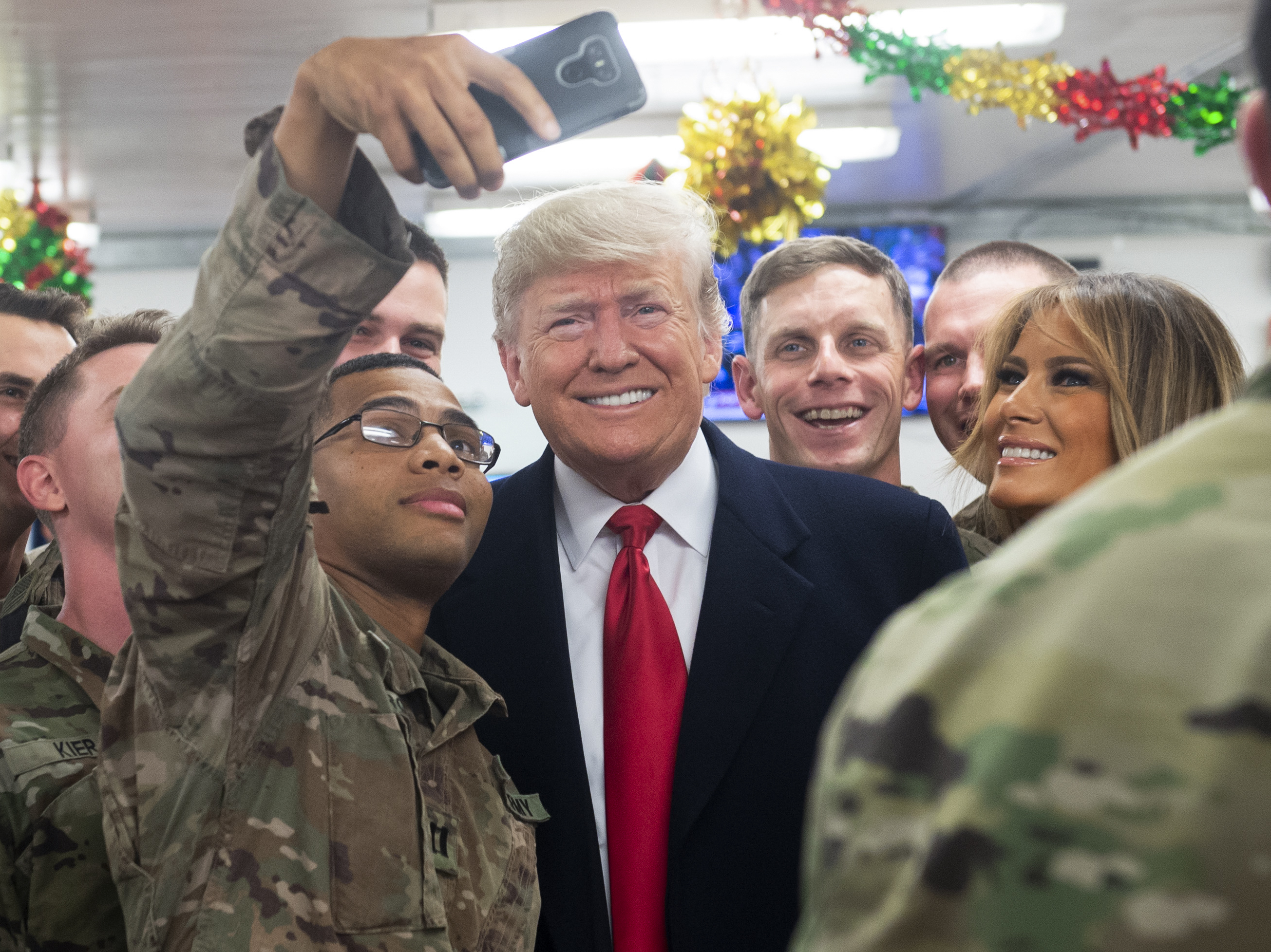 caption: President Trump and first lady Melania Trump greet members of the U.S. military during an unannounced trip to al-Asad Air Base in Iraq on Wednesday.