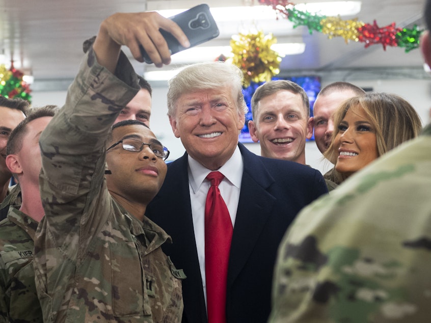 caption: President Trump and first lady Melania Trump greet members of the U.S. military during an unannounced trip to al-Asad Air Base in Iraq on Wednesday.