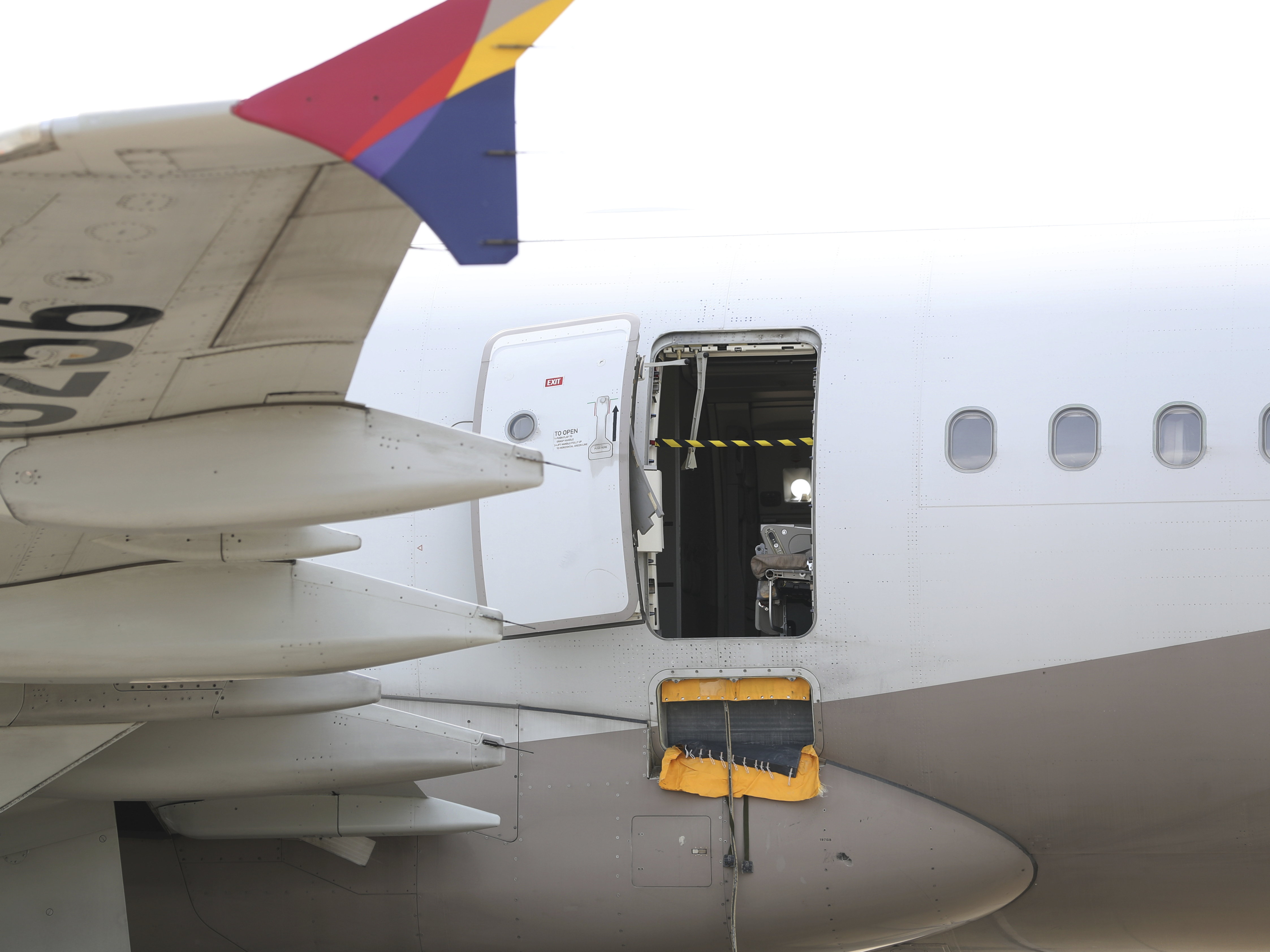caption: An Asiana Airlines plane is parked as one of the plane's doors suddenly opened at Daegu International Airport in Daegu, South Korea, Friday, May 26, 2023.
