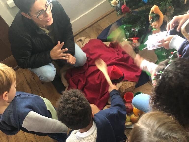 caption: Laia Vicens Fuste held a holiday party with the Casal dels Catalans de California,a local Catalan culture group. There, kids participated in the Tió de Nadal tradition. Laia's own kids speak English, Spanish and Catalan, and she says passing down cultural traditions is an important way she stayed connected to her roots while she lived in the U.S. (Courtesy of Laia Vicens Fuste)