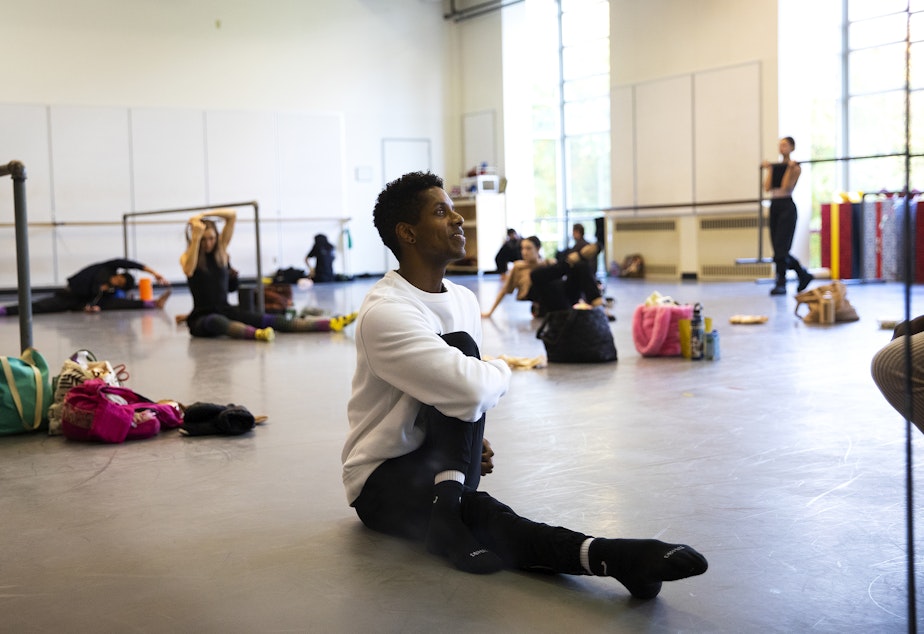 caption: Jonathan Batista, the first Black principal dancer in the history of the Pacific Northwest Ballet, stretches before rehearsal on Monday, Oct. 17, 2022, in Seattle. 