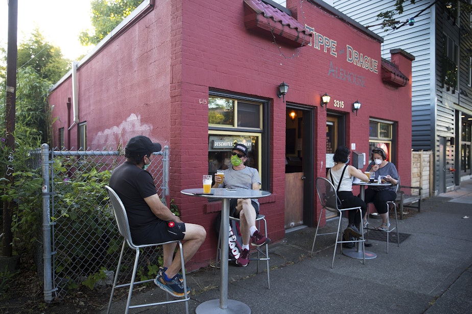 caption: Customers gather outside of the Tippe and Drague Alehouse on Tuesday, July 14, 2020, on Beacon Avenue South in Seattle. 