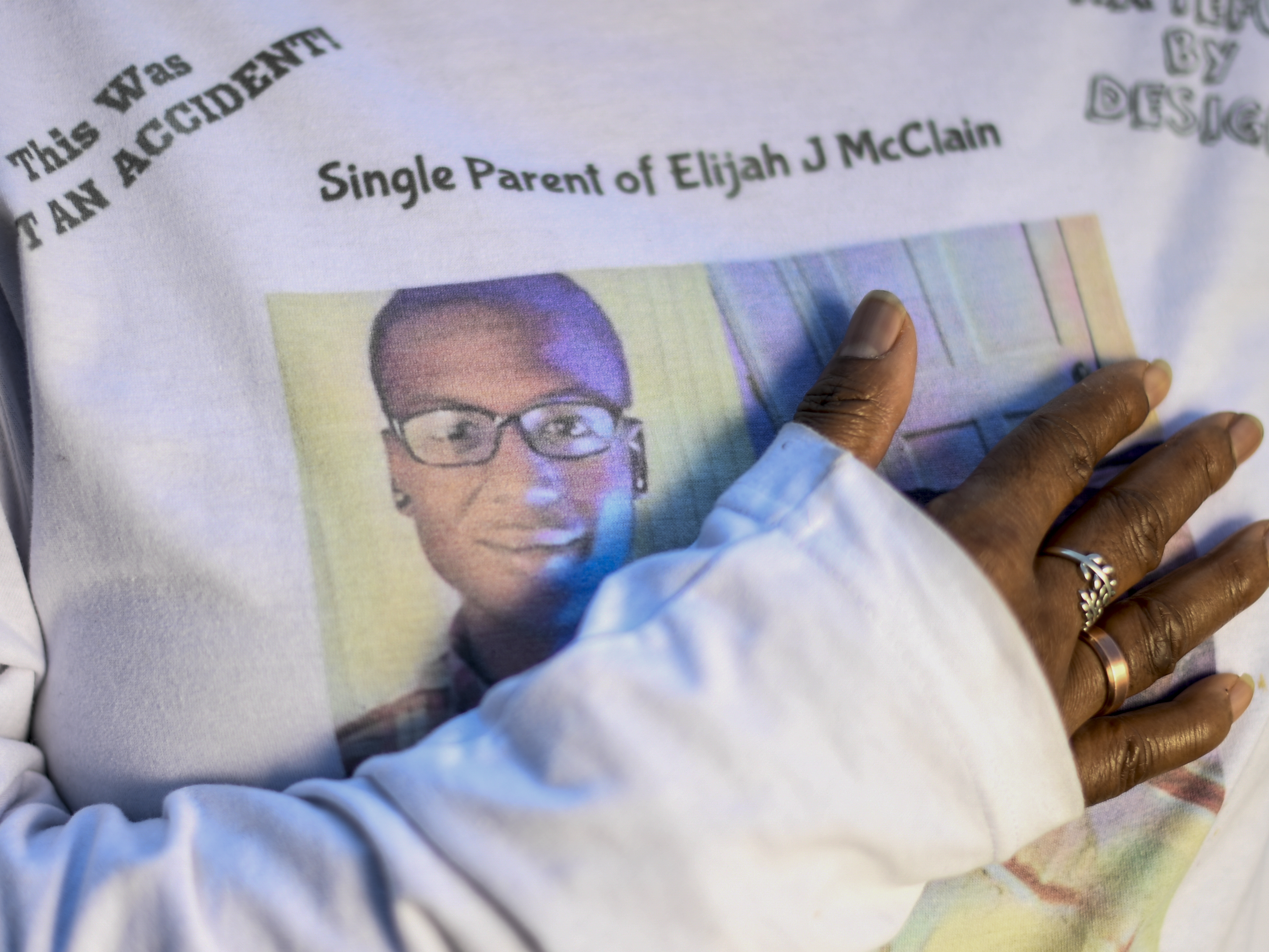 caption: Sheneen McClain stands at the site where her son Elijah was killed after an interaction with Aurora Police officers and paramedics resulted in the 23-year-old being restrained, choked and given a sedative on Aug. 24, 2019. Elijah McClain died less than a week later after leaving the scene unconscious and unable to breathe under his own power.