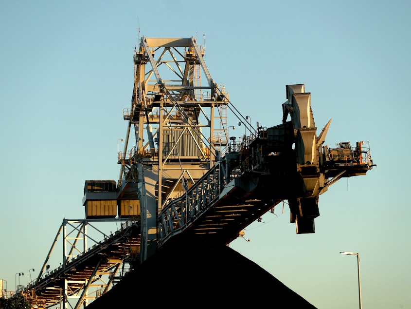 caption: A stacker-reclaimer next to a stockpile of coal at the Newcastle Coal Terminal in Newcastle, New South Wales. Australia is a major coal producer. A new draft agreement at the climate summit in Scotland calls for ending coal power.