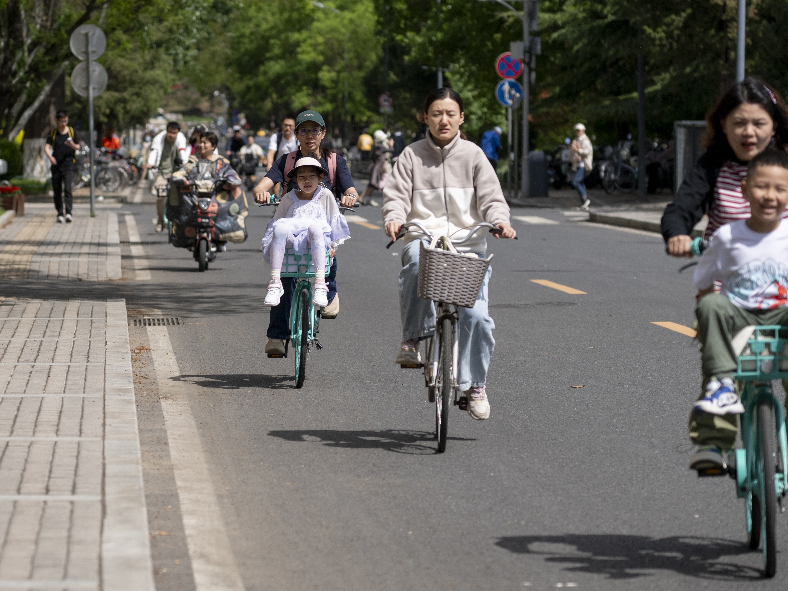 caption: People cycling in Tsinghua University in Beijing, China on April 23, 2024. 