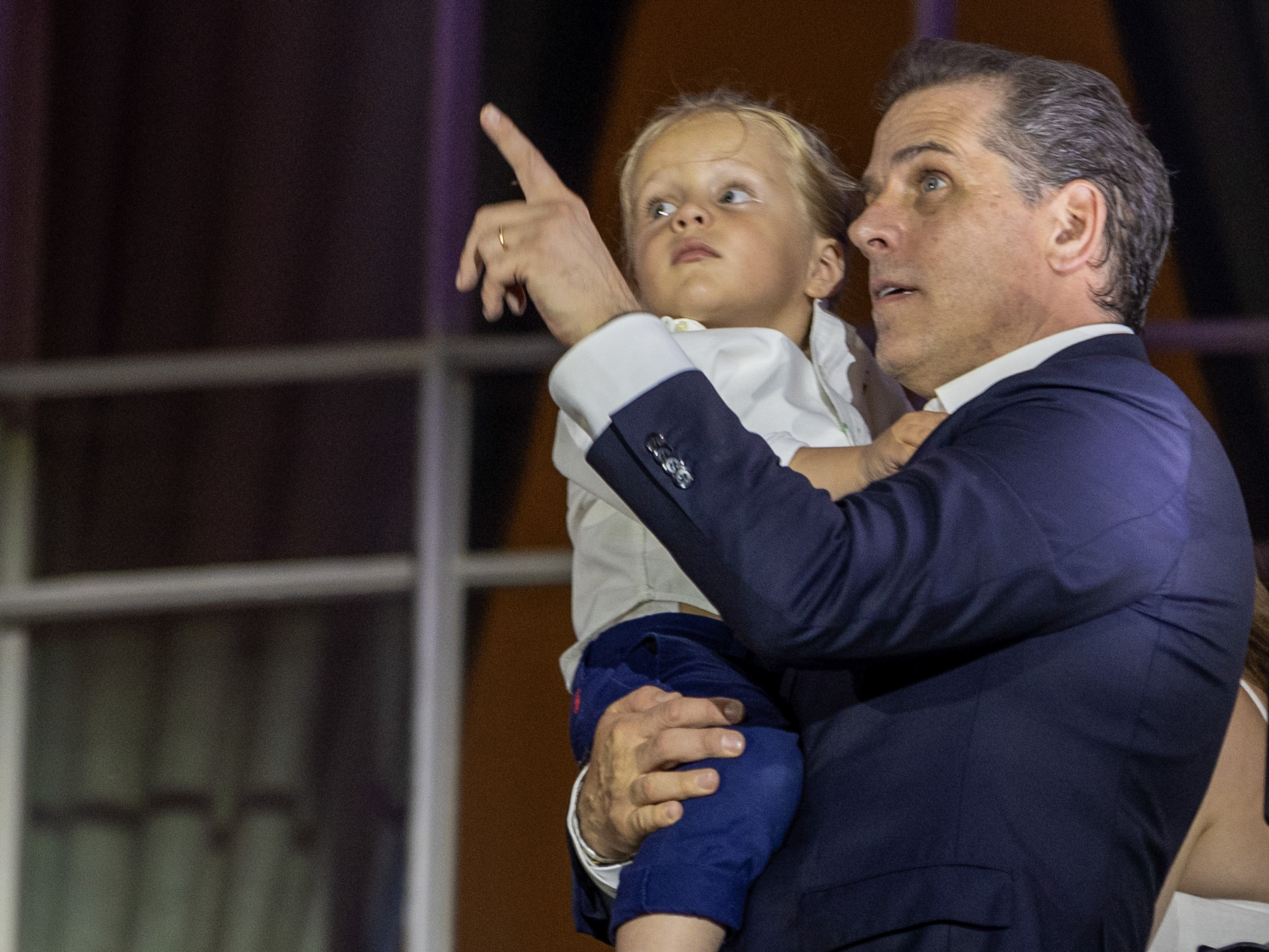 caption: Hunter Binden, holding Beau Biden, watches fireworks on the South Lawn of the White House on July 04, 2023 in Washington, D.C.
