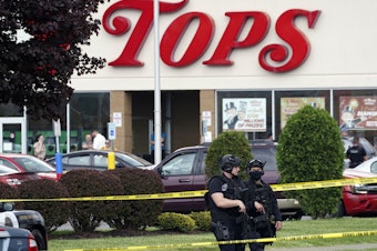 caption: Police secure an area around a Buffalo, N.Y., supermarket where 10 people were killed in a shooting on May 14, 2022.