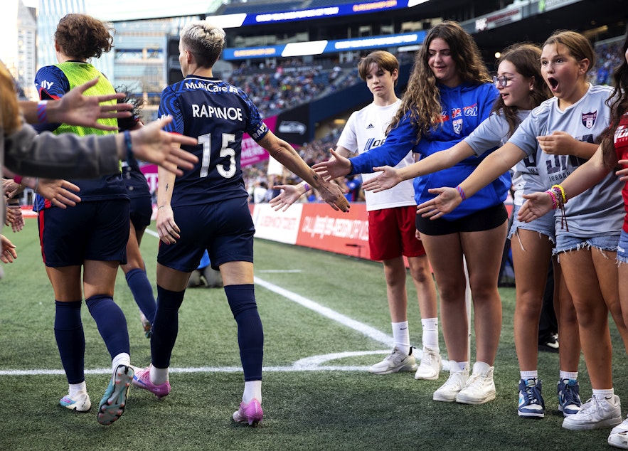 caption: Young fans react after high-fiving OL Reign forward Megan Rapinoe as she walks onto the field to play her final NWSL regular-season home game against the Washington Spirit on Friday, October 6, 2023, at Lumen Field in Seattle. 