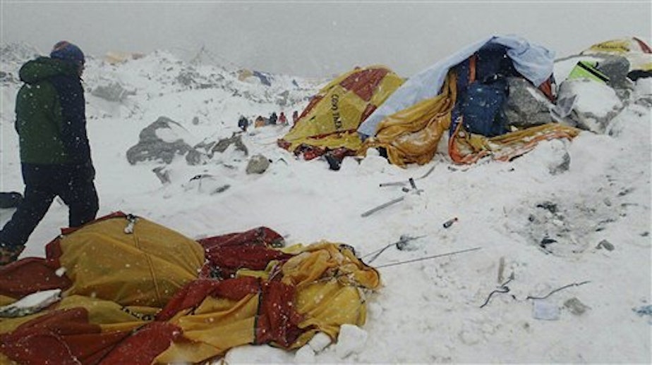 caption: In this photo provided by Azim Afif a man approaches the scene after an avalanche triggered by a massive earthquake swept across Everest Base Camp, Nepal on Saturday, April 25, 2015. 