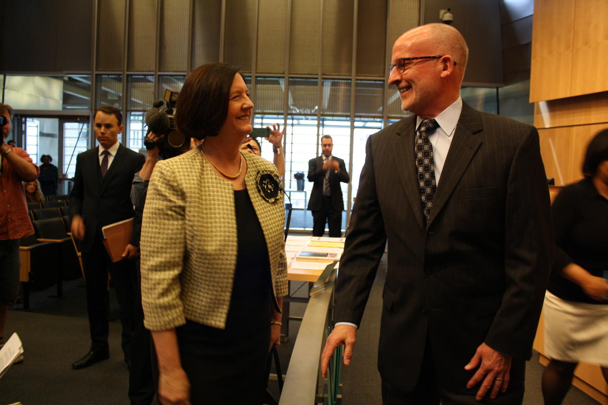 caption: Kathleen O'Toole chats with Seattle City Councilmember Tim Burgess before sitting down to talk with the Public Safety Committee.