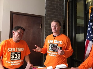 caption: In this file photo from 2018, anti-tax activist Tim Eyman holds a news conference after dropping off petitions for his last car tab reduction ballot measure.