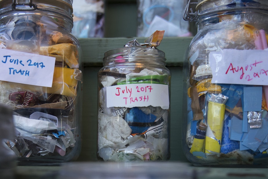 caption: Jars filled with the garbage that Deb Seymour has accumulated over each month of 2017 are shown at her home on Wednesday, December 20, 2017, in Seattle. 