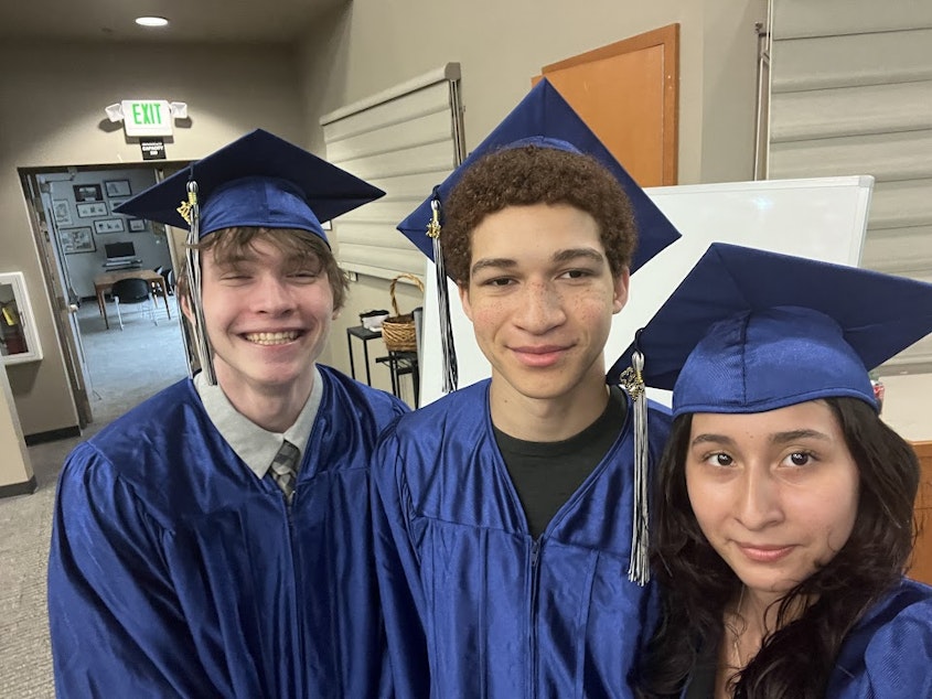 caption: Eva Miranda (right) poses for a photo with two fellow graduates at Eastside Academy's graduation ceremony.