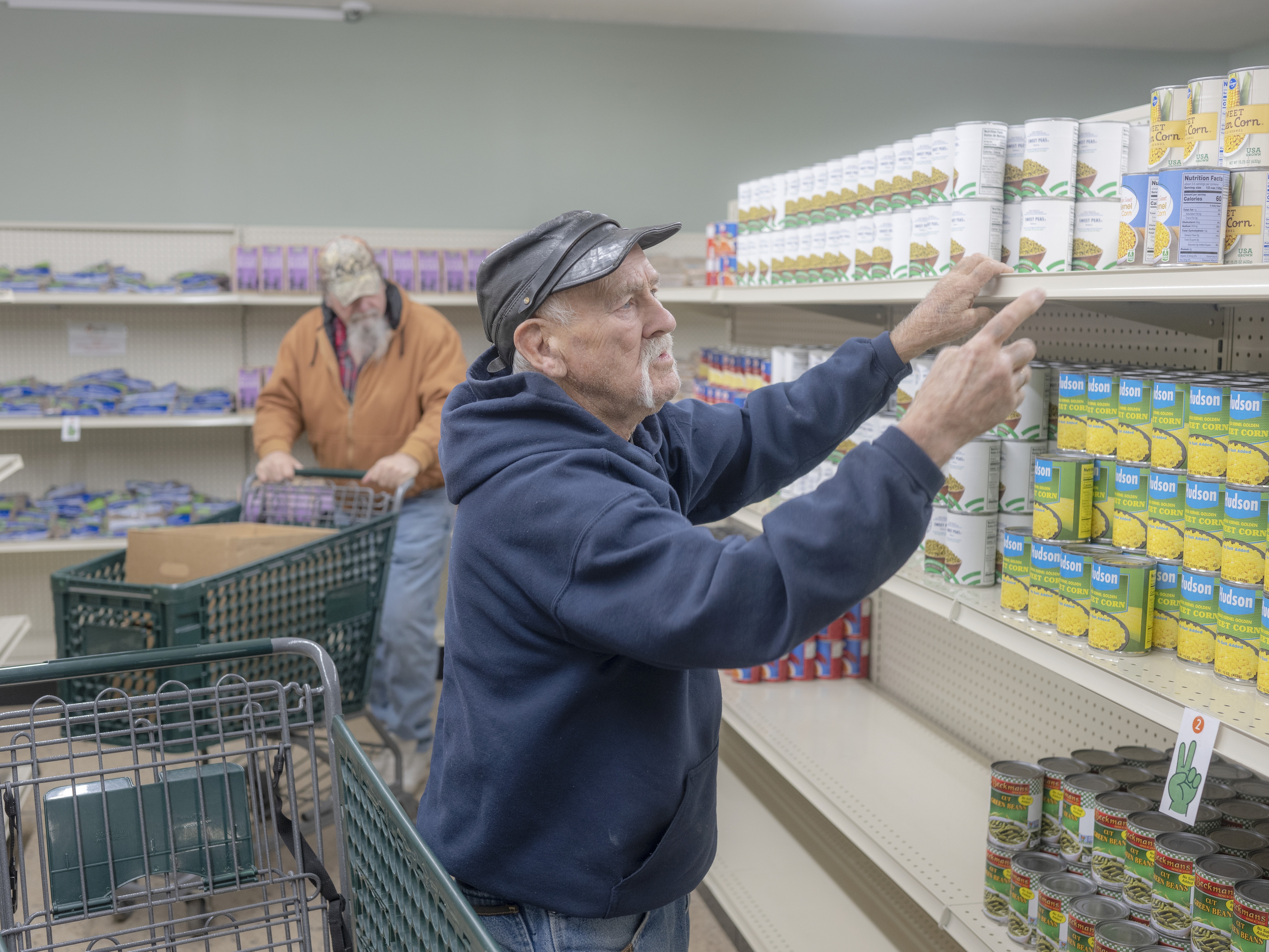 caption: Paul B. Miller shops at The Market food pantry in Logan, Ohio on Dec. 9.  Food aid was just one of many services offered here that faced disruption in 2025.