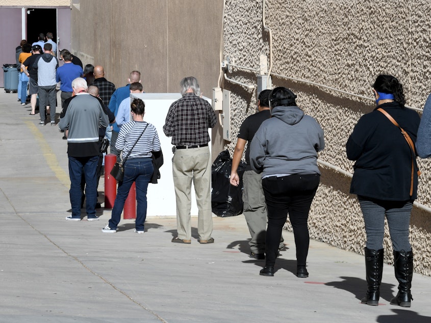 caption: People line up on Thursday for the first day of Clark County's pilot COVID-19 vaccination program at Cashman Center in Las Vegas.