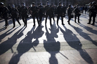 caption: Police officers form a line on Saturday, Feb. 10, 2018, outside of a College Republicans rally at Red Square on the University of Washington campus in Seattle. 