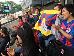 caption: Tibetans cheer on a Tibetan team at a soccer tournament in London. Fans say they were pleased and surprised that the tournament organizers didn't succumb to pressure from potential sponsors and dump the Tibetan team to avoid angering the Chinese government.