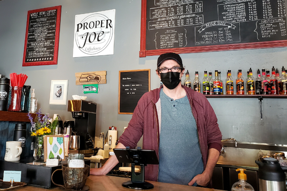 caption: Aaron Donohue offers free masks and hand sanitizer at Proper Joe Coffeehouse in Snohomish on Monday, August 23, 2021.
