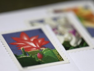 caption: The price of a first-class stamp will go up 3 cents later in August to help pay for service changes.