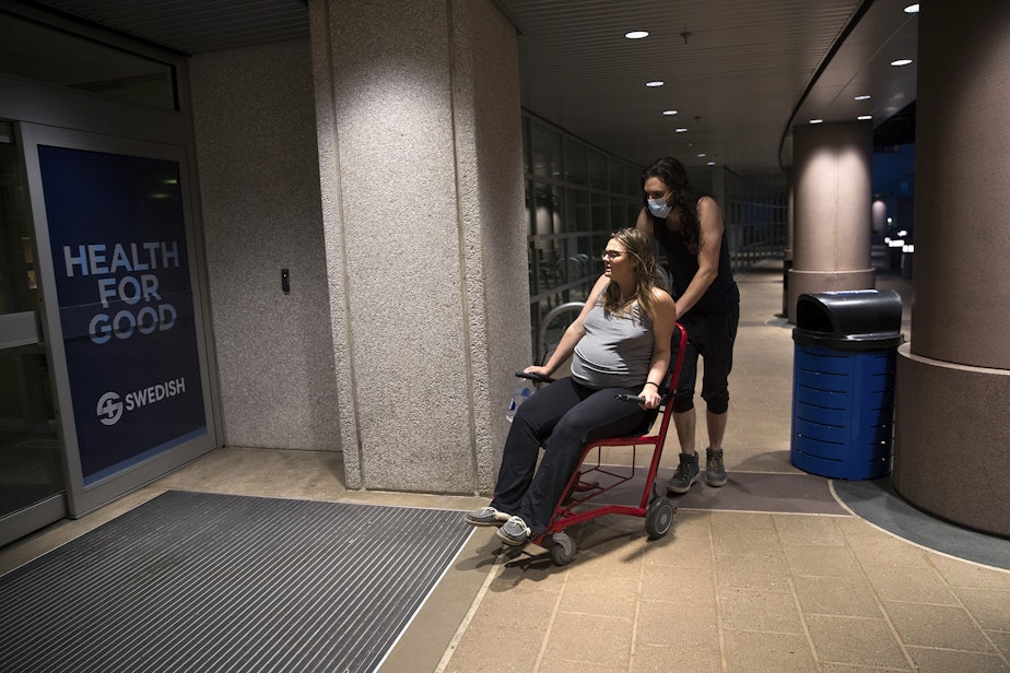 caption: Jake and Hope Black make their way into the Swedish First Hill emergency room at 9:13 p.m. on Friday, May 28, 2020, in Seattle. 