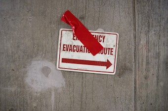 caption: An Emergency Evacuation Route sign is shown on Tuesday, March 27, 2018, inside the SR 99 tunnel in Seattle.
