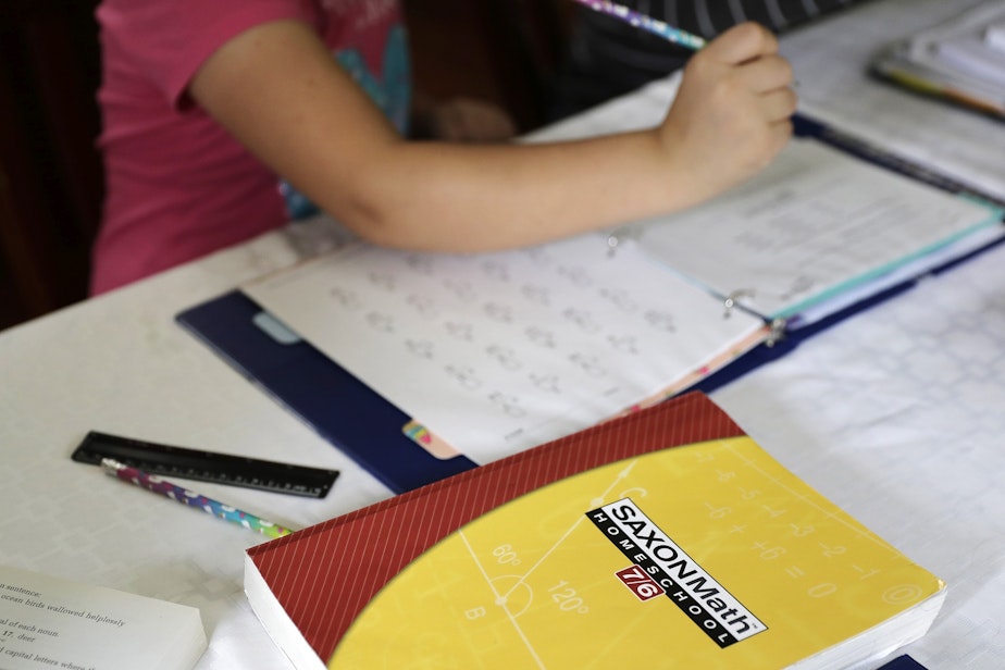 caption: In this Oct. 9, 2019 photo, a homeschool math textbook rests on the table where Mabry Grant, 8, works on a lesson with her mom, Donya Grant, at their home in Monroe, Wash.
