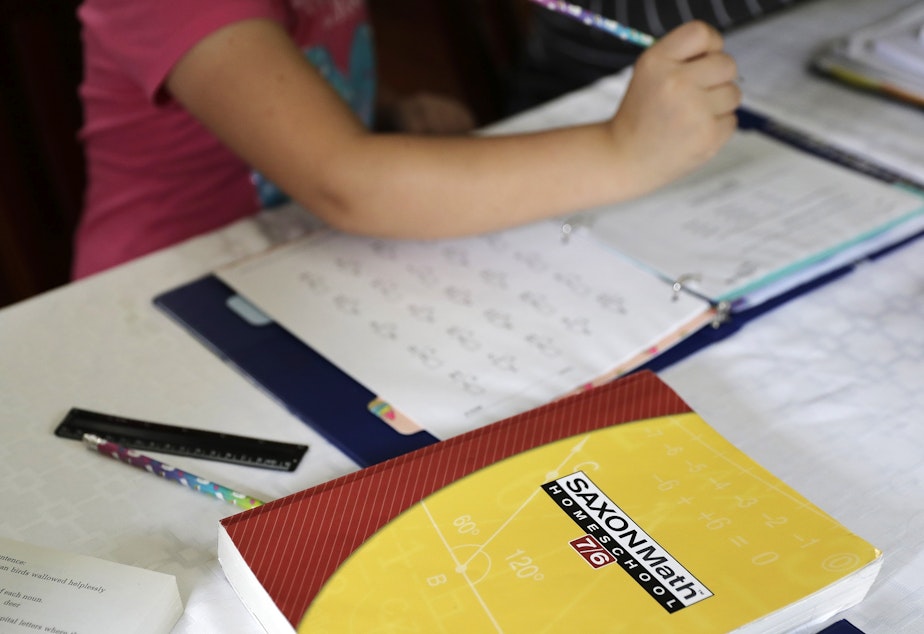 caption: In this Oct. 9, 2019 photo, a homeschool math textbook rests on the table where Mabry Grant, 8, works on a lesson with her mom, Donya Grant, at their home in Monroe, Wash. 