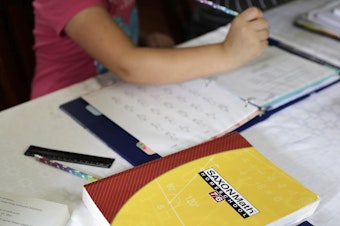 caption: In this Oct. 9, 2019 photo, a homeschool math textbook rests on the table where Mabry Grant, 8, works on a lesson with her mom, Donya Grant, at their home in Monroe, Wash. 