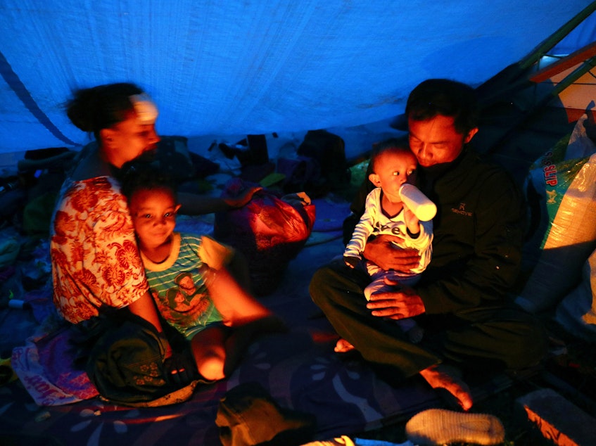 caption: Relief agencies are mobilizing to help thousands of people affected by Indonesia's earthquake and tsunami. Here, people are seen taking refuge in a temporary shelter in Palu, Central Sulawesi, on Tuesday.