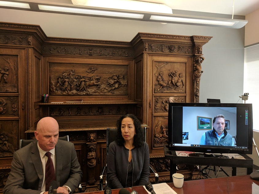 caption: Attorneys Brad Moore, Karen Koehler and John Layman speaking at a press conference. They're bringing a lawsuit against Seattle Children's seeking class action status