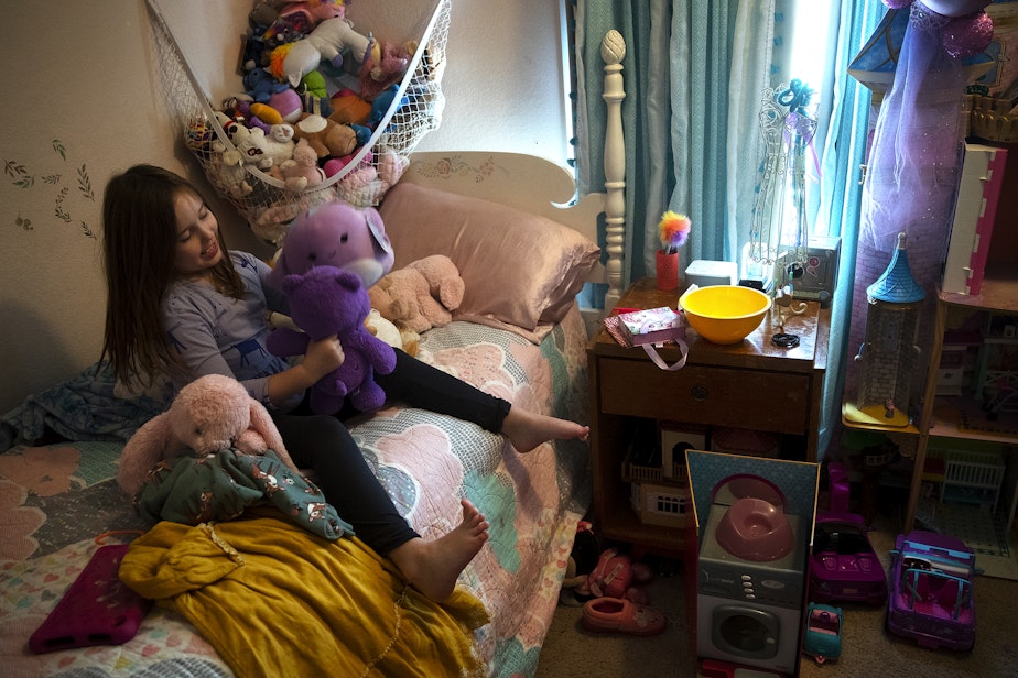 caption: Lily Butler, 7, plays with stuffed animals in her bedroom after school on Wednesday, November 22, 2023, in Kenmore. 