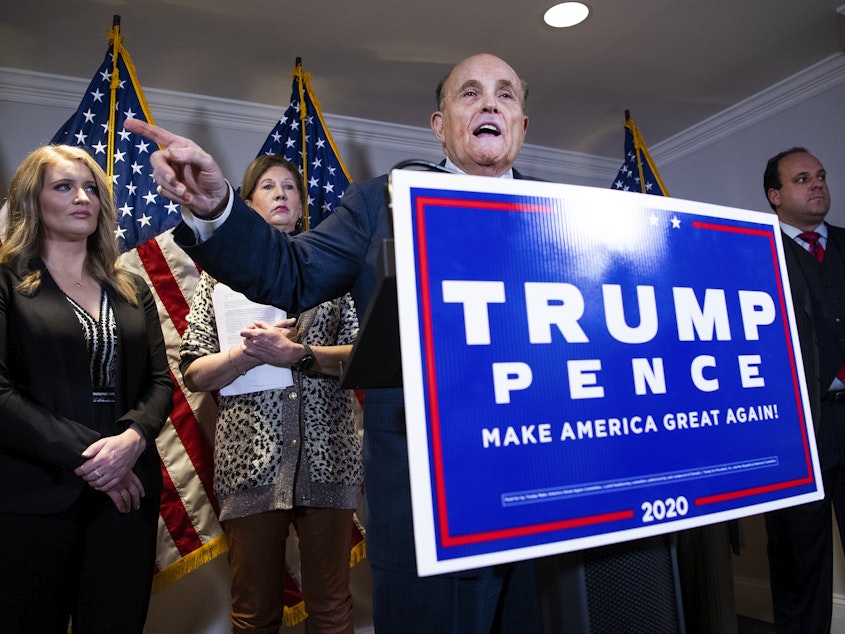 caption: Rudolph Giuliani, attorney for President Donald Trump, conducts a news conference at the Republican National Committee on lawsuits regarding the outcome of the 2020 presidential election on Thursday, November 19, 2020. Trump attorneys Jenna Ellis, far left, and Sydney Powell, second from left, and Boris Boris Epshteyn, right, also appear.