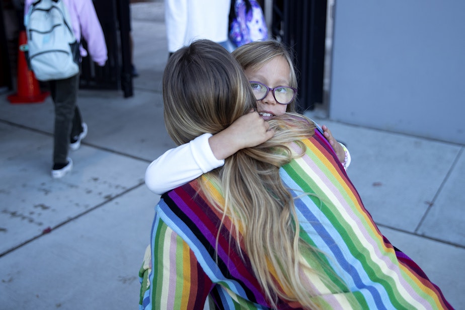 caption: Naomi Cook, 7, hugs her mom, Katie Wear, before her first day of 2nd-grade on Wednesday, September 6, 2023, at Daniel Bagley Elementary School in Seattle.