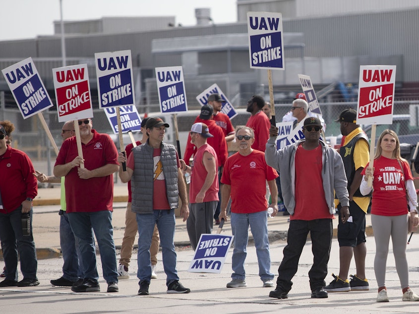 caption: United Auto Workers members strike at the Ford Michigan Assembly Plant on September 16, 2023 in Wayne, Michigan. This is the first time in history that the UAW is striking all three of the Big Three auto makers, Ford, General Motors, and Stellantis, at the same time.