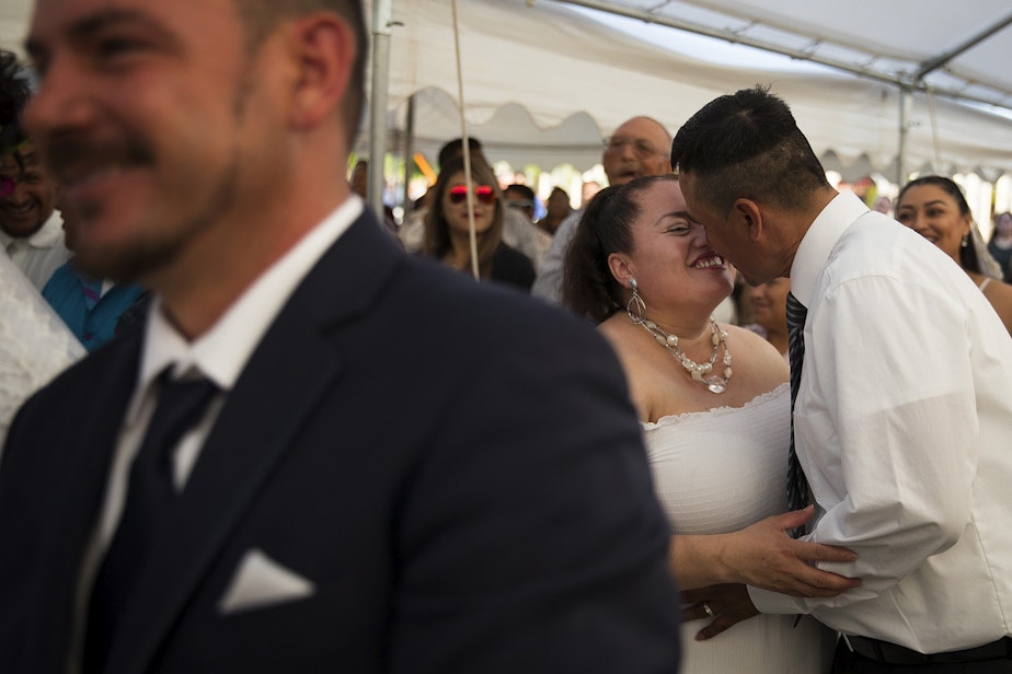 caption: Ana Dely Morales and Ramon Sanchez Cordova share a kiss during a mass wedding ceremony where they were married along with 22 other couples on Sunday, June 2, 2019, at Our Lady of the Desert Church in Mattawa. 