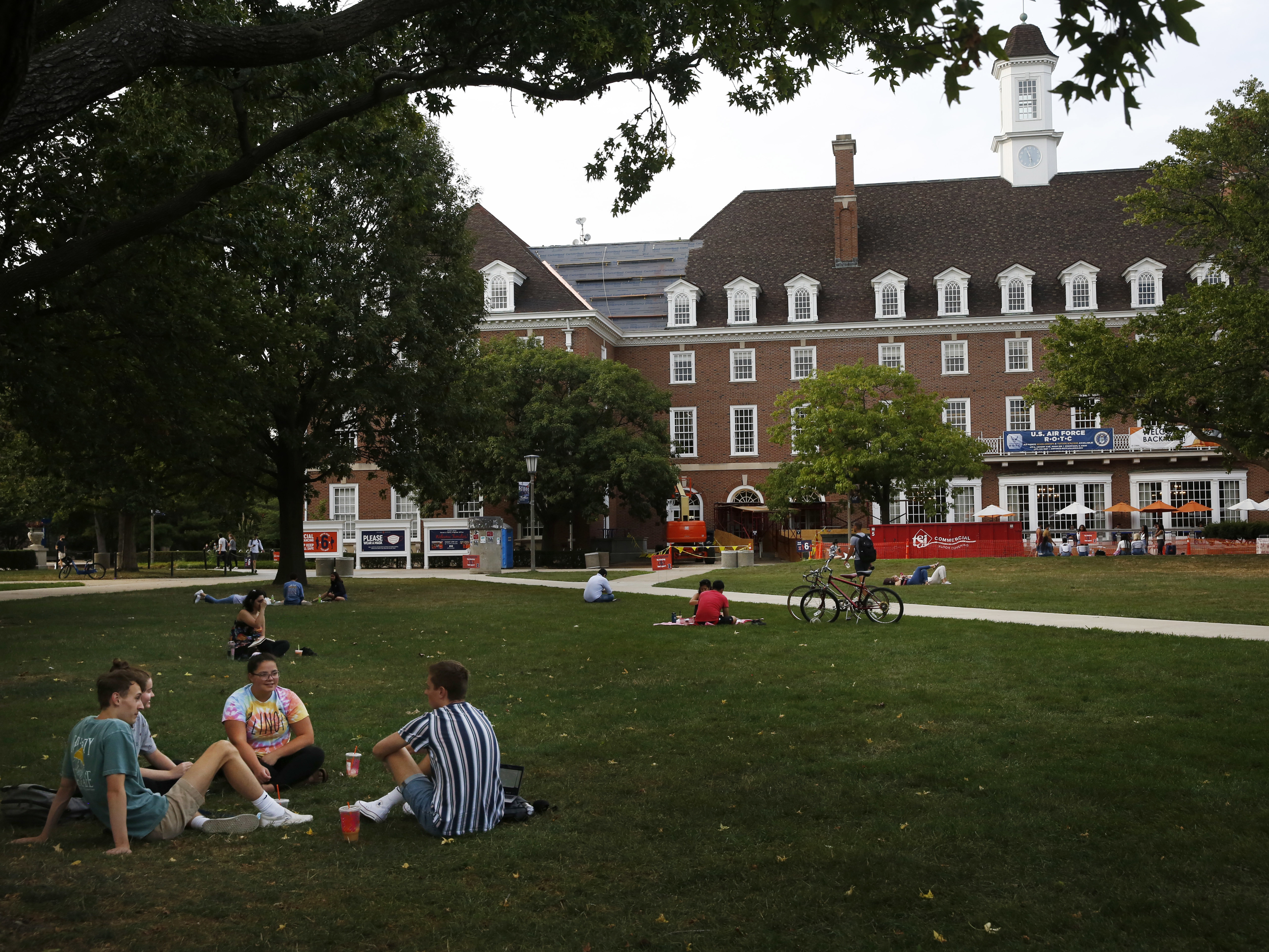 caption: Students chat on a lawn this fall at the University of Illinois at Urbana-Champaign. It's unclear how disruptions to campus life during the pandemic might affect student voter turnout on Election Day.