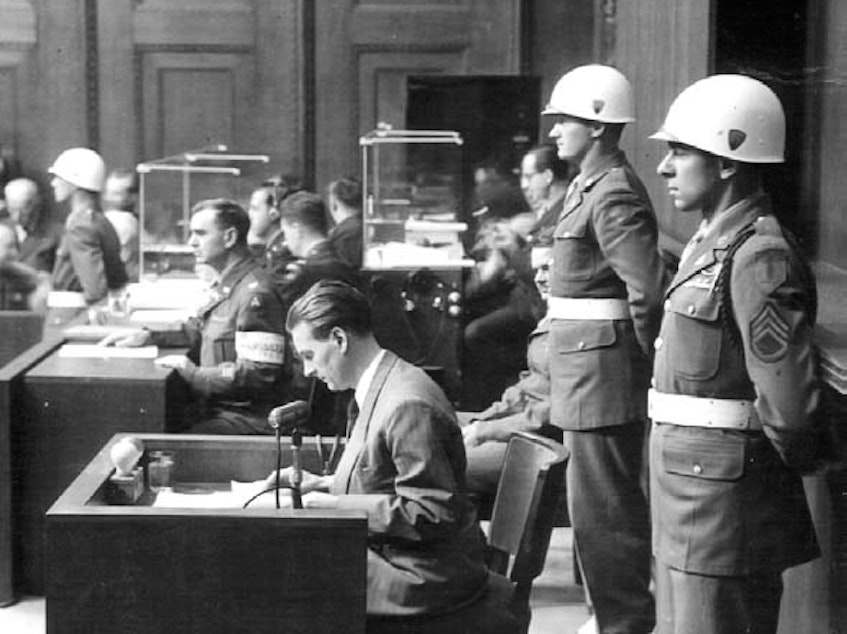 caption: Staff Sgt. Emilio DiPalma (right) stands on guard at the Nuremberg Trials in 1945.