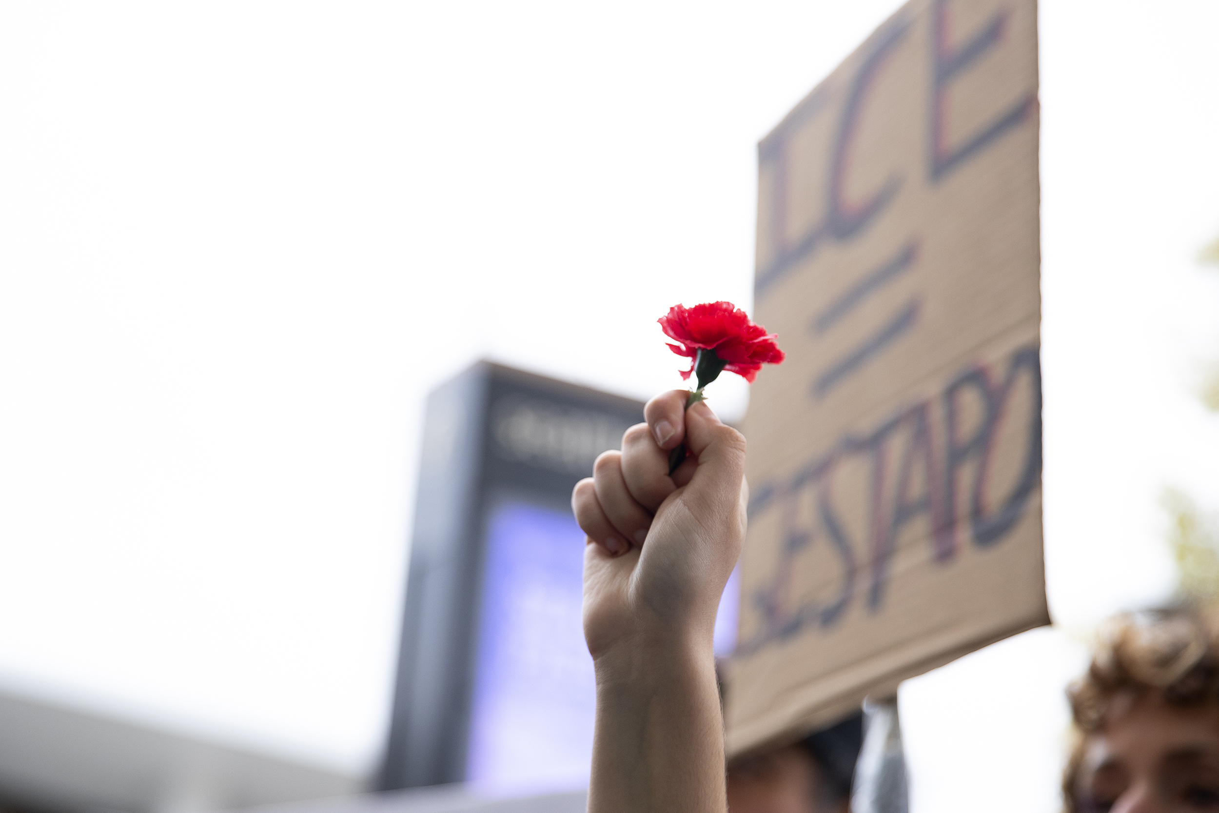 caption: Nora Hermosilla, 15, holds a flower in the air while listening to speakers at the No Kings rally on Saturday, October 18, 2025, at Seattle Center. 