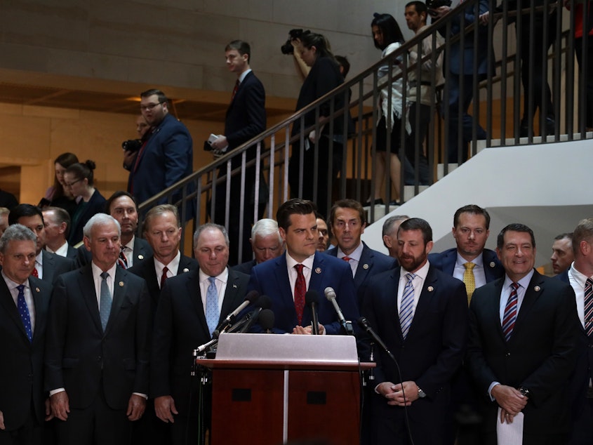 caption: Flanked by about two dozen House Republicans, U.S. Rep. Matt Gaetz, R-Fla., argues that all GOP lawmakers should have access to closed-door depositions in the impeachment inquiry. Committee rules dictate that only those on the panels conducting the probe can attend.