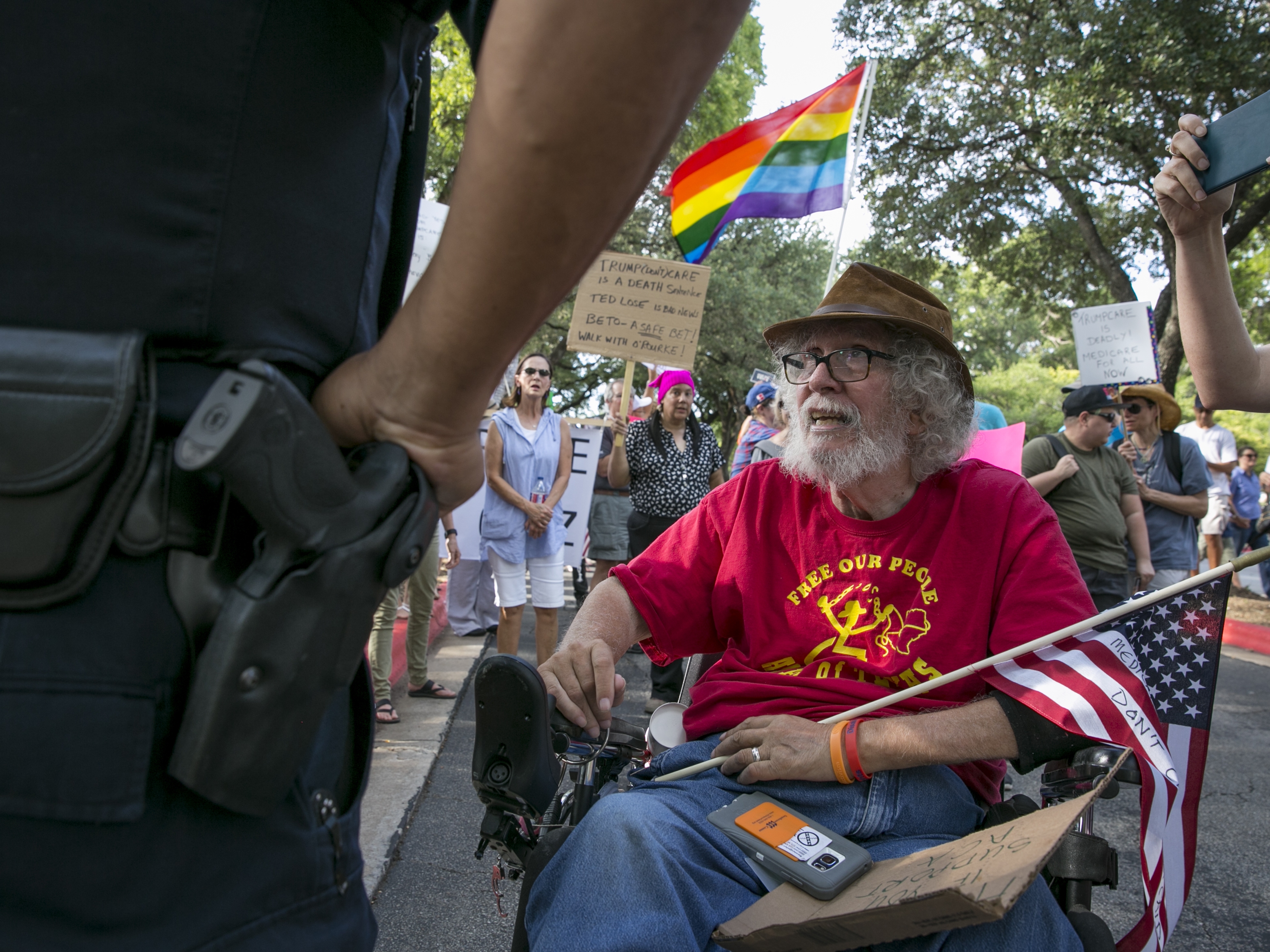 caption: Bob Kafka, a disabled Vietnam veteran, talks with an Austin Police Officer as he and others try to enter a hotel property.