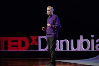 caption: Brett Hennig on the TED stage.