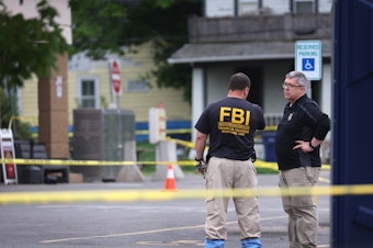 caption: As police and FBI agents continue their investigation into the shooting at Tops Market in Buffalo, N.Y., last weekend, Congress is considering legislation to address domestic terrorism. Authorities say the attack was believed to be motivated by racial hatred.