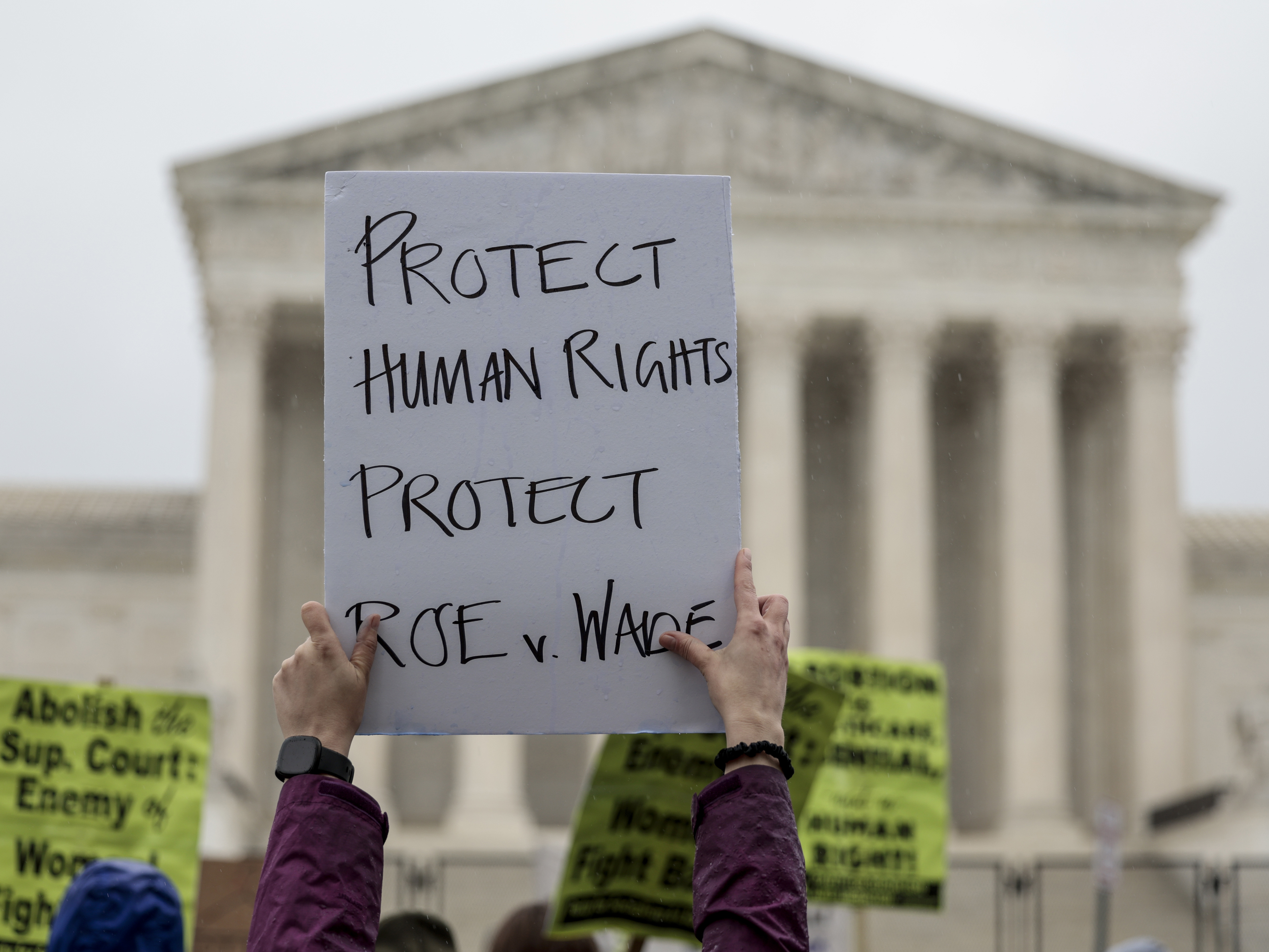 caption: An abortion-rights protester holds up a sign during a demonstration in front of the Supreme Court on Saturday in Washington, D.C. Less than a week since the leaked draft of the Court's potential decision to overturn <em>Roe v. Wade,</em> protesters on both sides of the abortion debate continue to demonstrate in front of the building which has been fortified by a temporary fence.