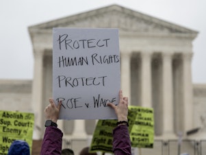 caption: An abortion-rights protester holds up a sign during a demonstration in front of the Supreme Court on Saturday in Washington, D.C. Less than a week since the leaked draft of the Court's potential decision to overturn <em>Roe v. Wade,</em> protesters on both sides of the abortion debate continue to demonstrate in front of the building which has been fortified by a temporary fence.