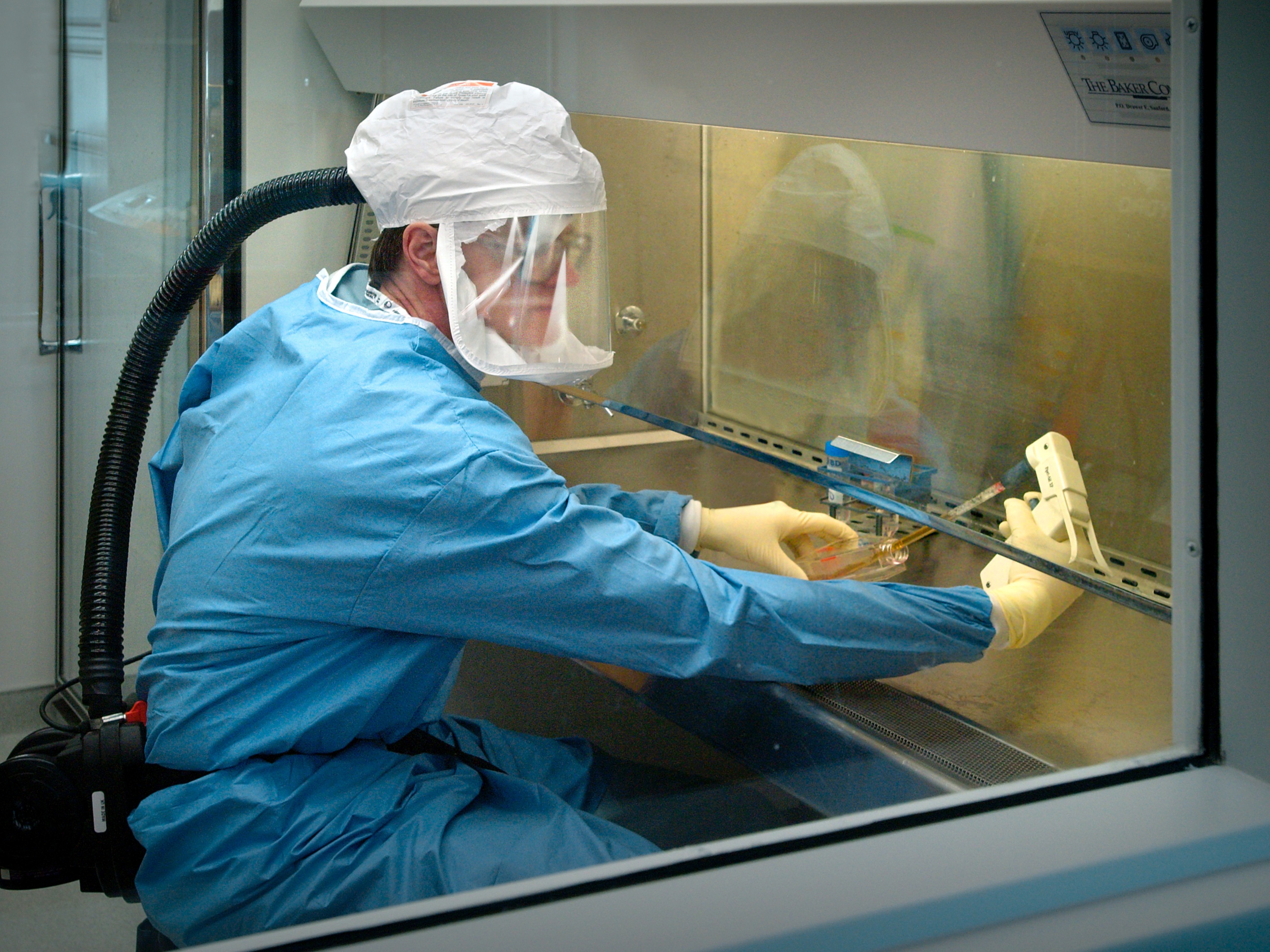 caption: A scientist at the Centers for Disease Control and Prevention, in an Atlanta laboratory, wears a protective air-tight suit when handling samples of influenze.