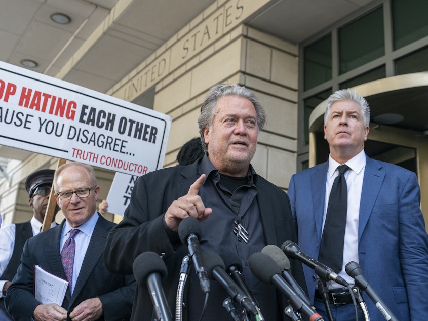 caption: Former White House strategist Steve Bannon, center, speaks with reporters as he departs federal court on Friday, July 22, 2022, in Washington. 